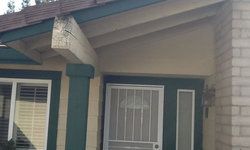 the front of a house with a screen door and a porch.
