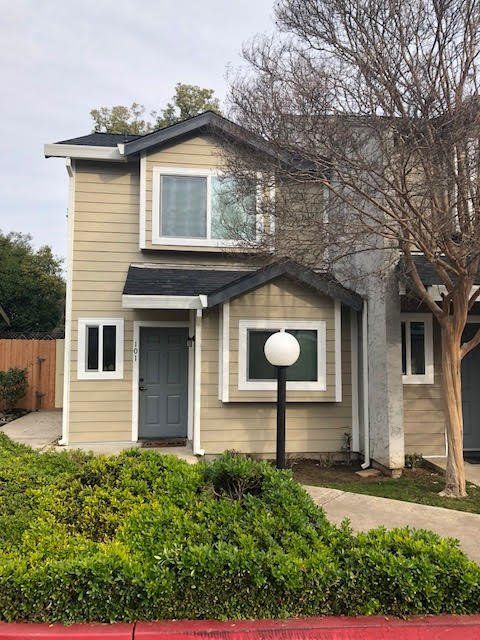 a house with a lot of windows and a lamp post in front of it .
