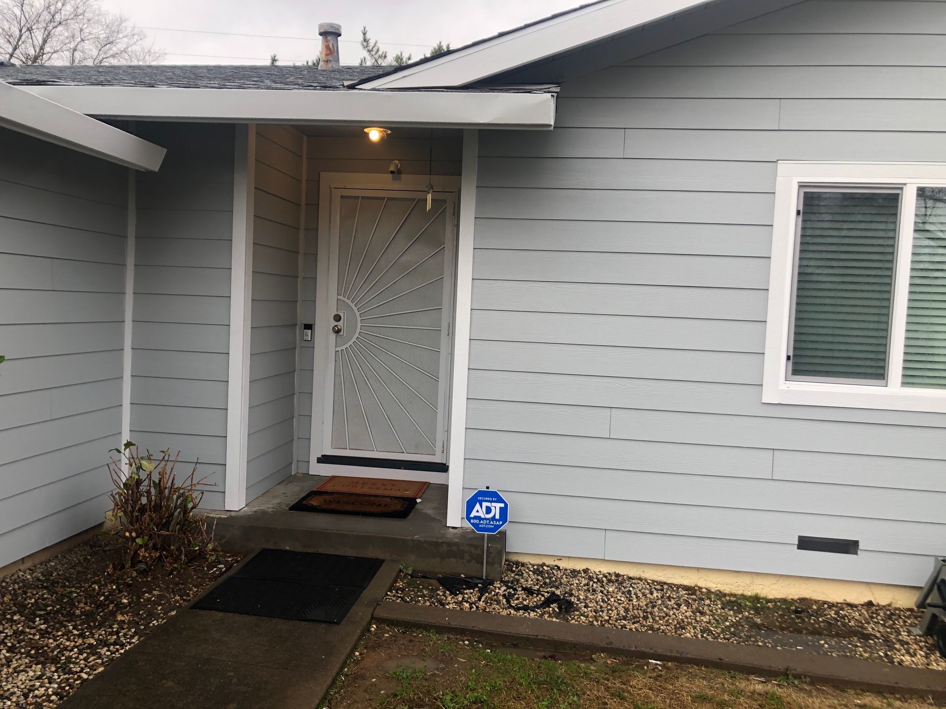 the front of a house with a porch and a window .