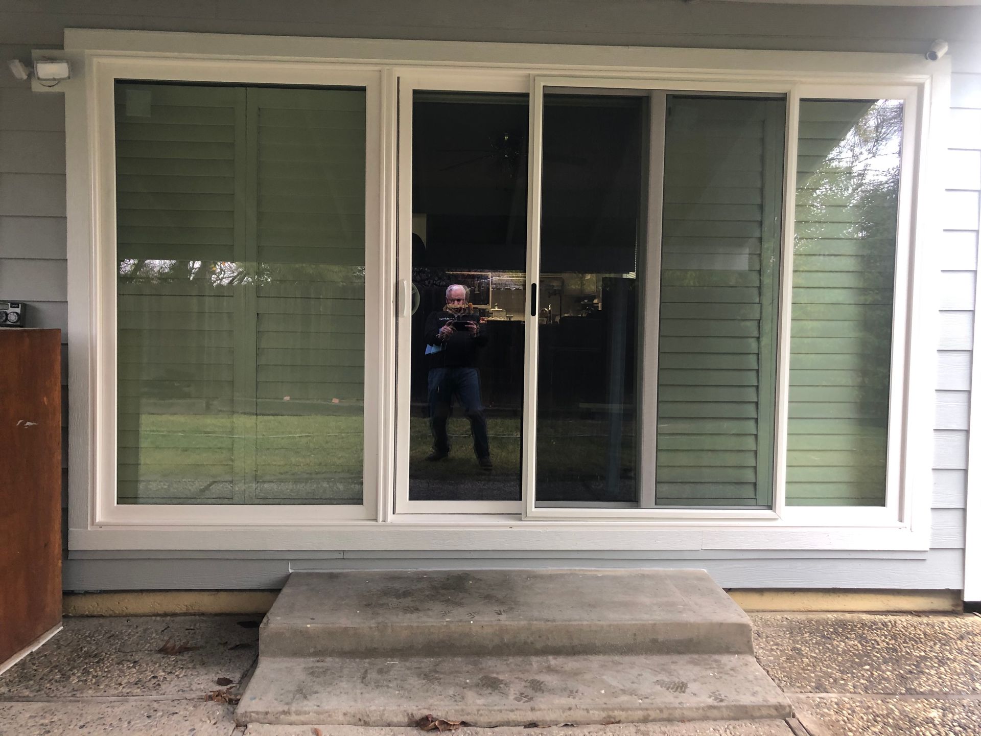 a man is standing in front of a sliding glass door.