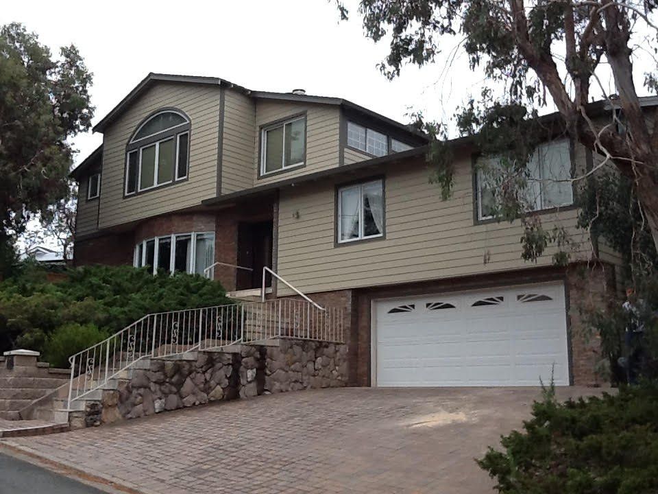 a large house with a white garage door and stairs.