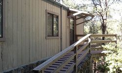 a wooden house with a wooden deck and stairs.