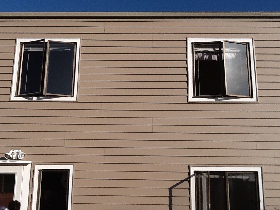 a house with two windows that are open.