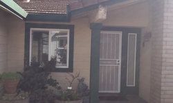 the front of a house with a porch and a window .
