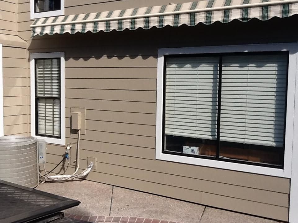 a house with a striped awning over the windows.