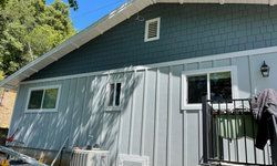a small house with a balcony and a lot of windows.
