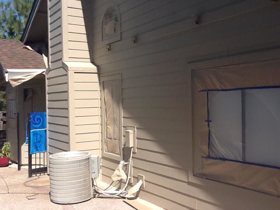 a house is being painted with a hose attached to it.