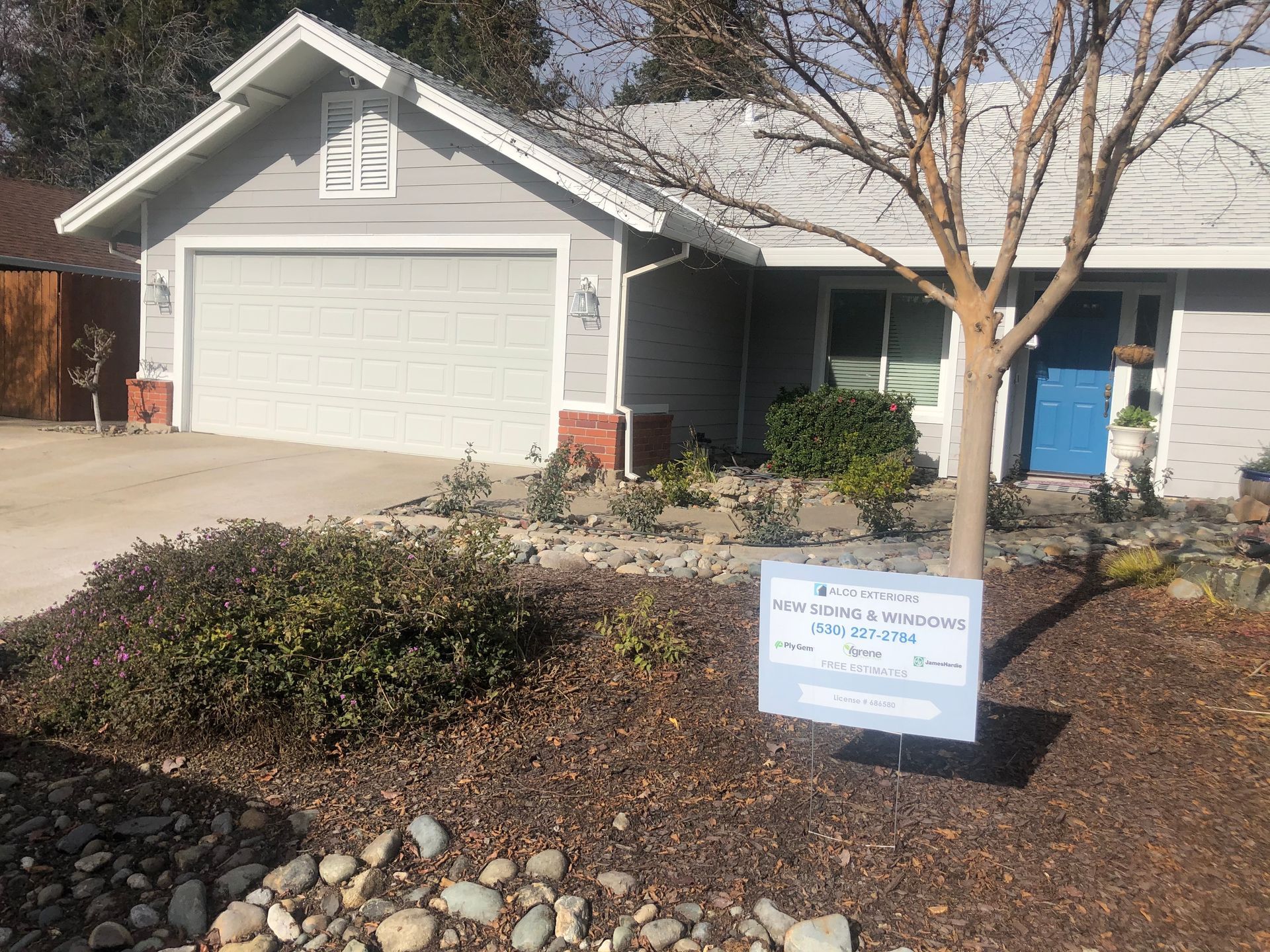 a house with a blue door and a sign in front of it.
