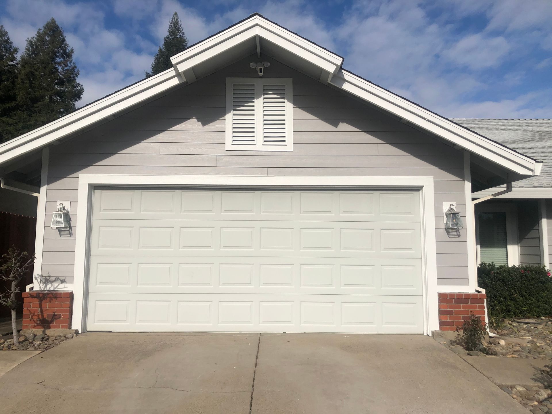 a white garage door is sitting in front of a house .