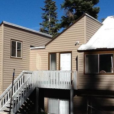 a house with a balcony and stairs leading up to it