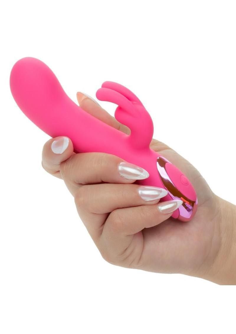 Hand holding a pink rabbit-shaped vibrator on a white background
