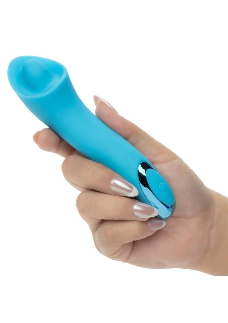 Hand holding a turquoise handheld personal massager against a white background