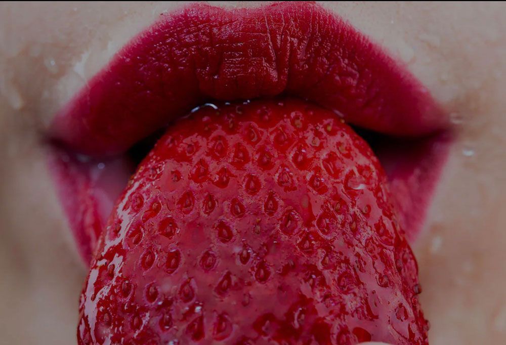 Picture of a woman eating a strawberry