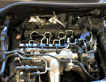 A close-up view of a car engine, showing various components like fuel lines and the engine block