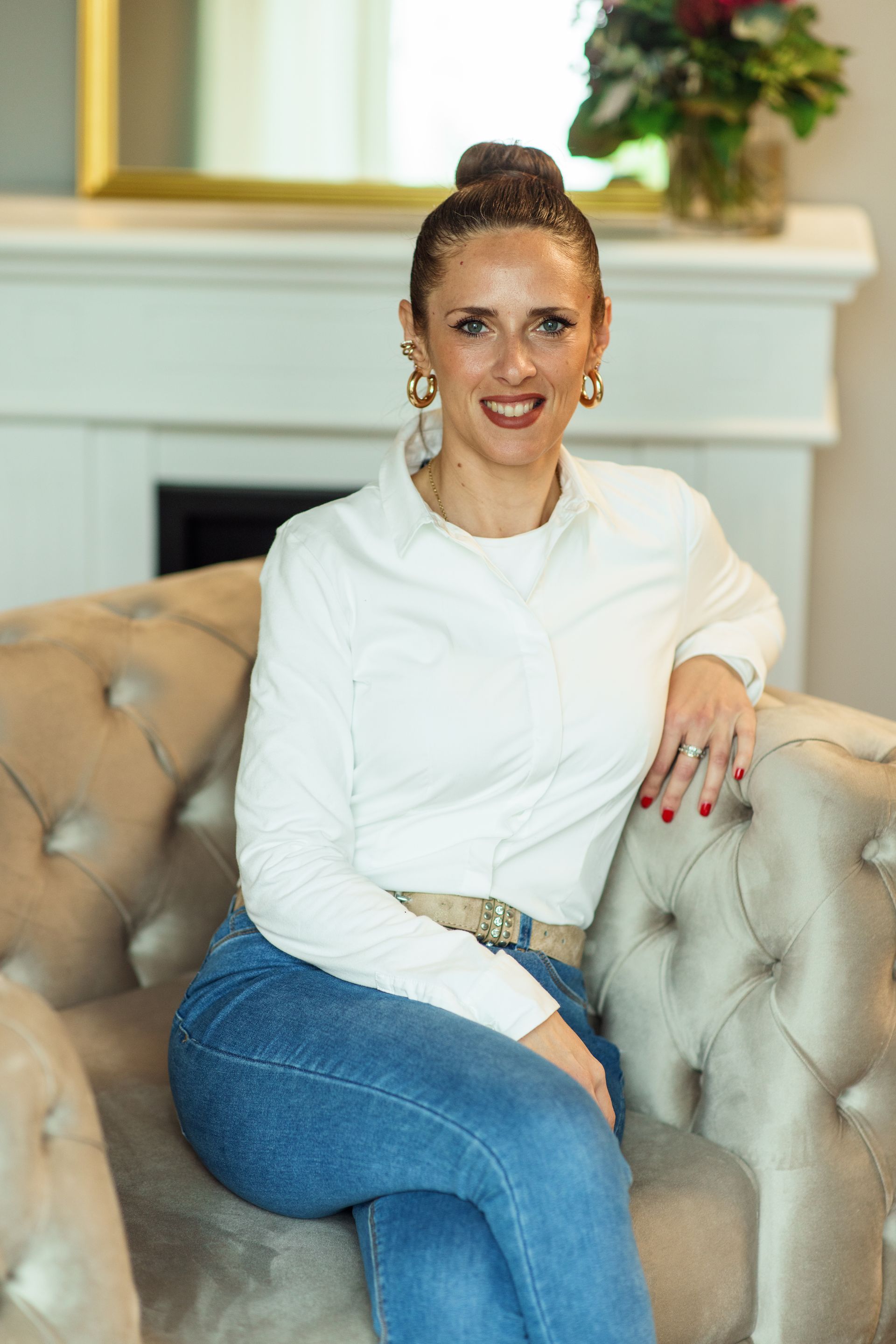 Eine Frau sitzt auf einem Sofa vor einem Kamin.