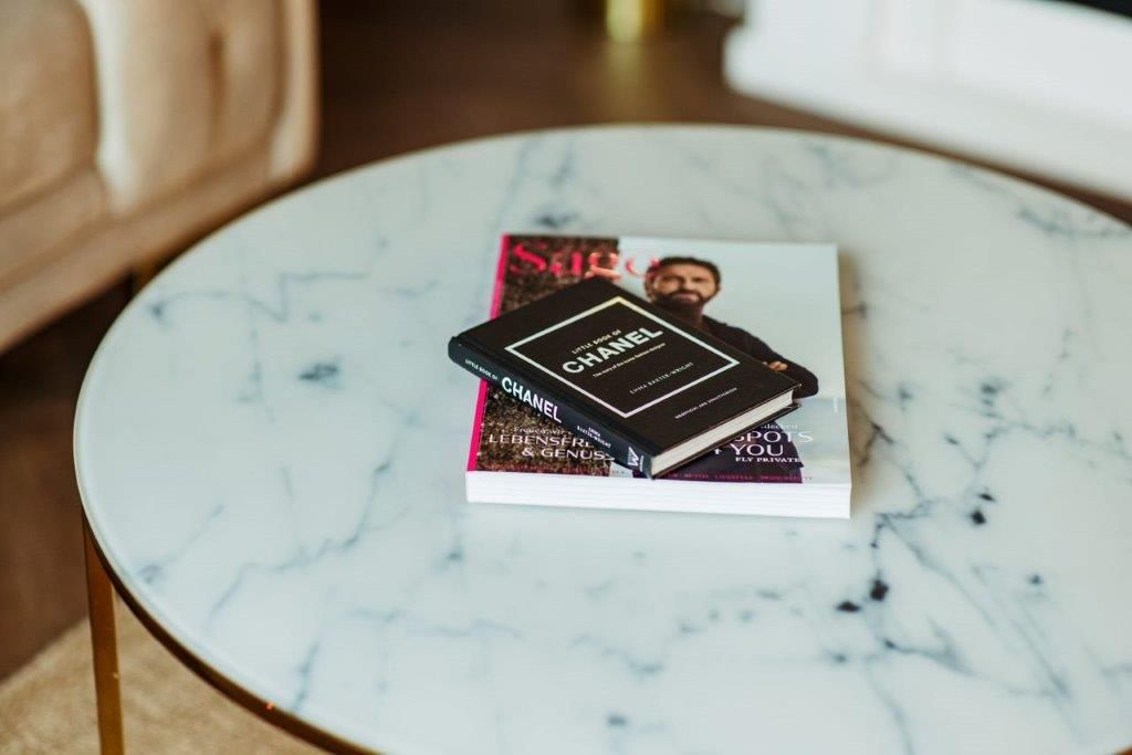 Ein Couchtisch aus Marmor mit einem Buch darauf.