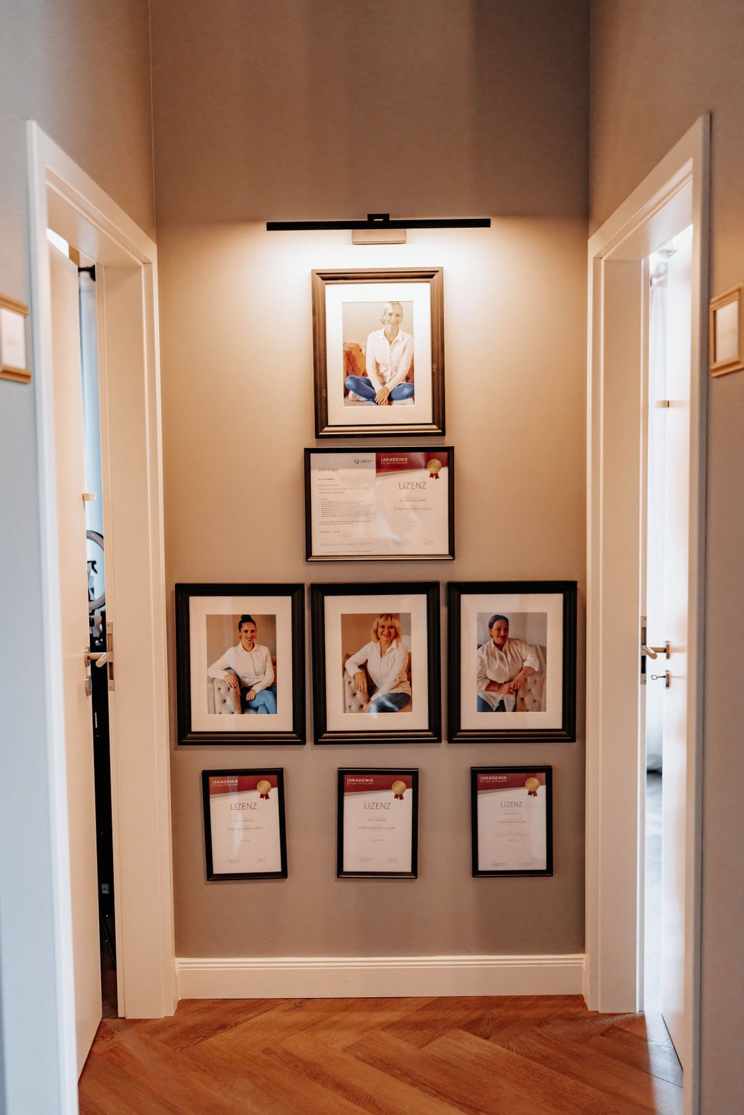 Ein Flur mit einer Reihe gerahmter Bilder an der Wand.