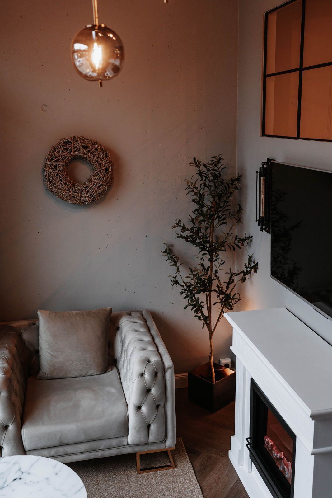 Ein Wohnzimmer mit Sessel, Kamin und Fernseher.