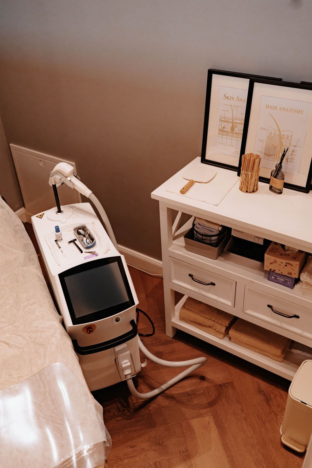 In einem Zimmer steht eine Maschine auf einem Tisch neben einem Bett.