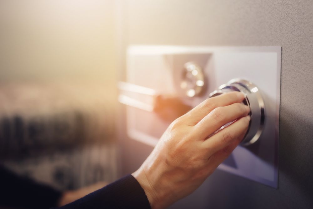 A Person Is Opening A Safe With A Bracelet In It — Fortress Locksmiths & Security in Hornsby, NSW