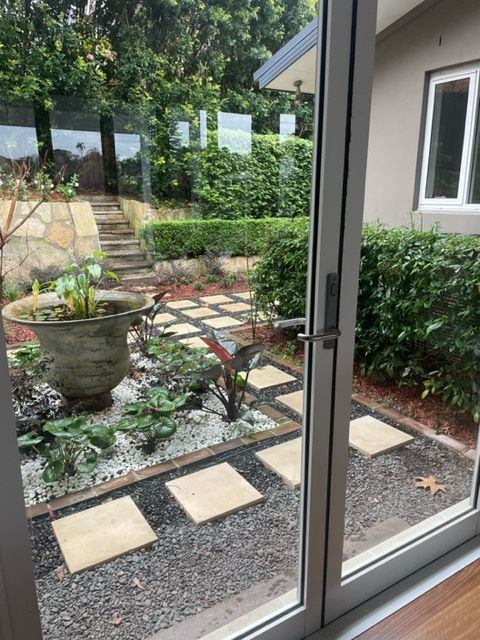 A View Of A Garden Through A Sliding Glass Door — Fortress Locksmiths & Security in Hornsby, NSW