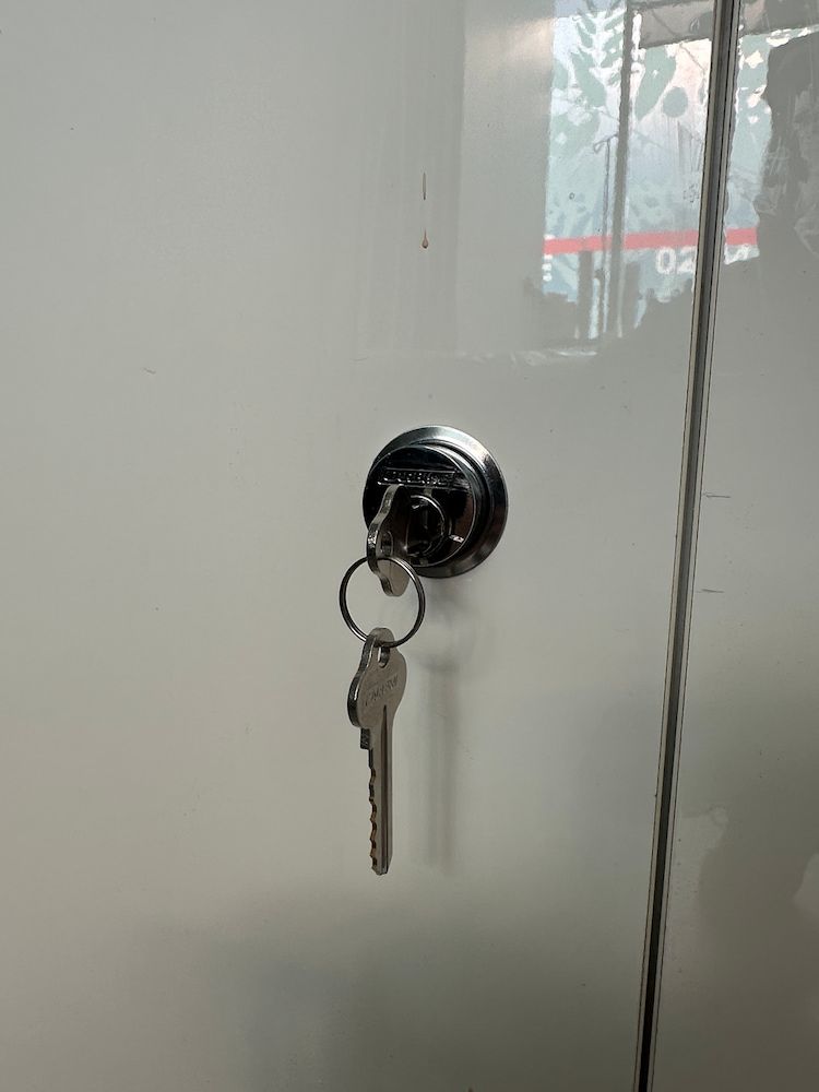 A Key In A Lock On A Glass Door — Fortress Locksmiths & Security in Hornsby, NSW