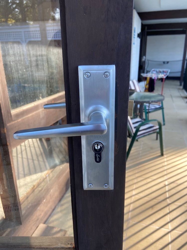 A Stainless Steel Door Handle With A Key On It — Fortress Locksmiths & Security in Chatswood, NSW