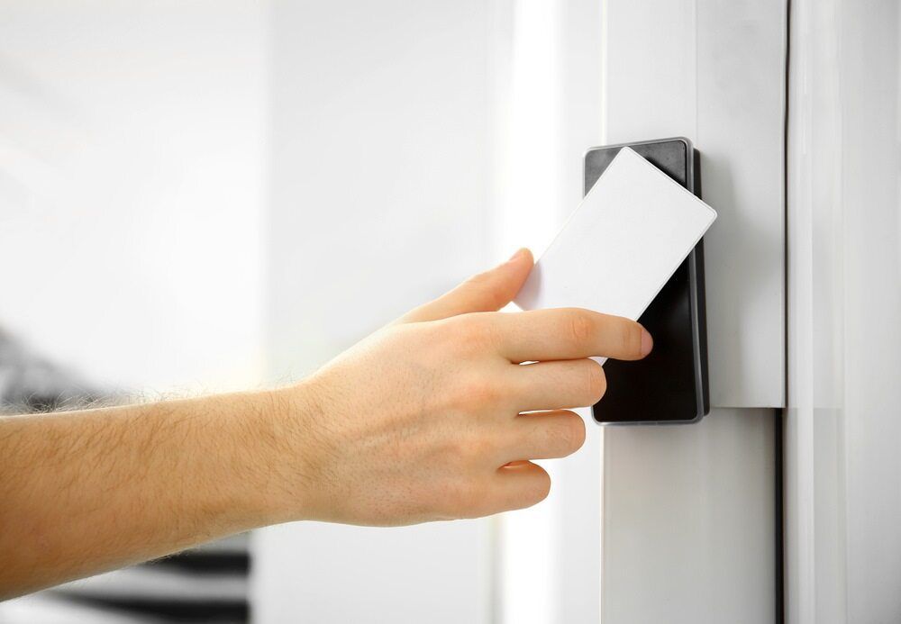 A Person Is Using A Key Card To Open A Door — Fortress Locksmiths & Security in Hornsby, NSW