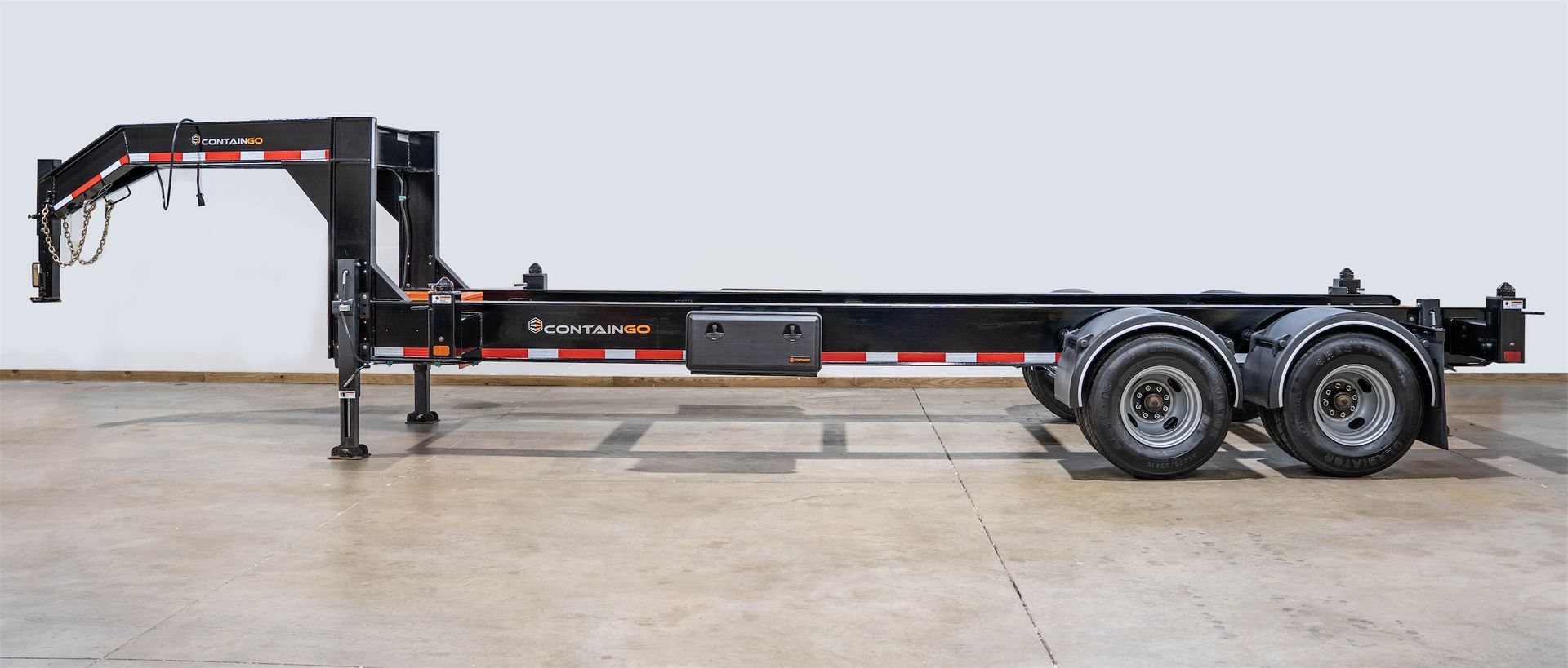 a Container Leveling Chassis Trailer is sitting on top of a concrete floor .