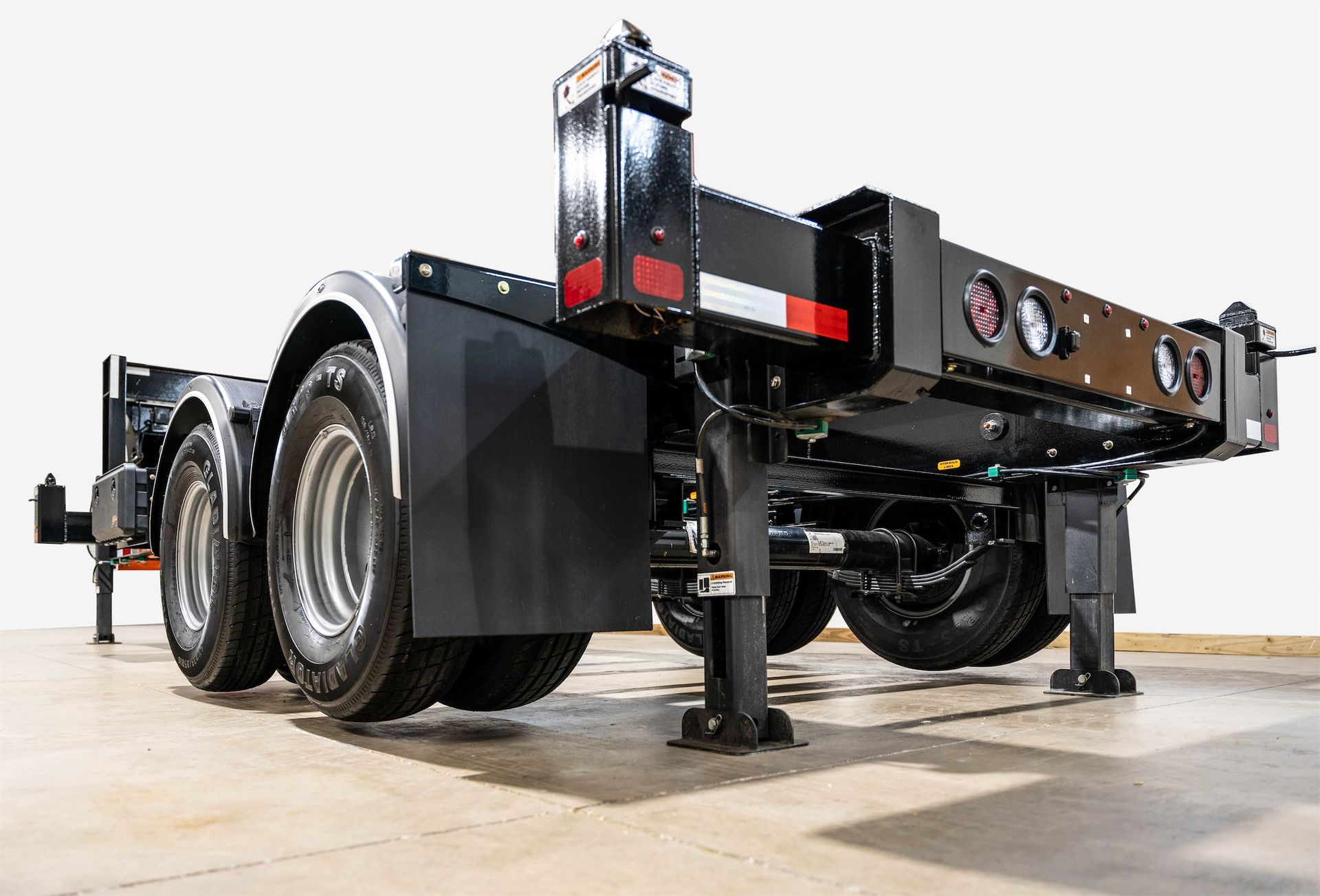 a Container Leveling Chassis Trailer is sitting on top of a warehouse floor .