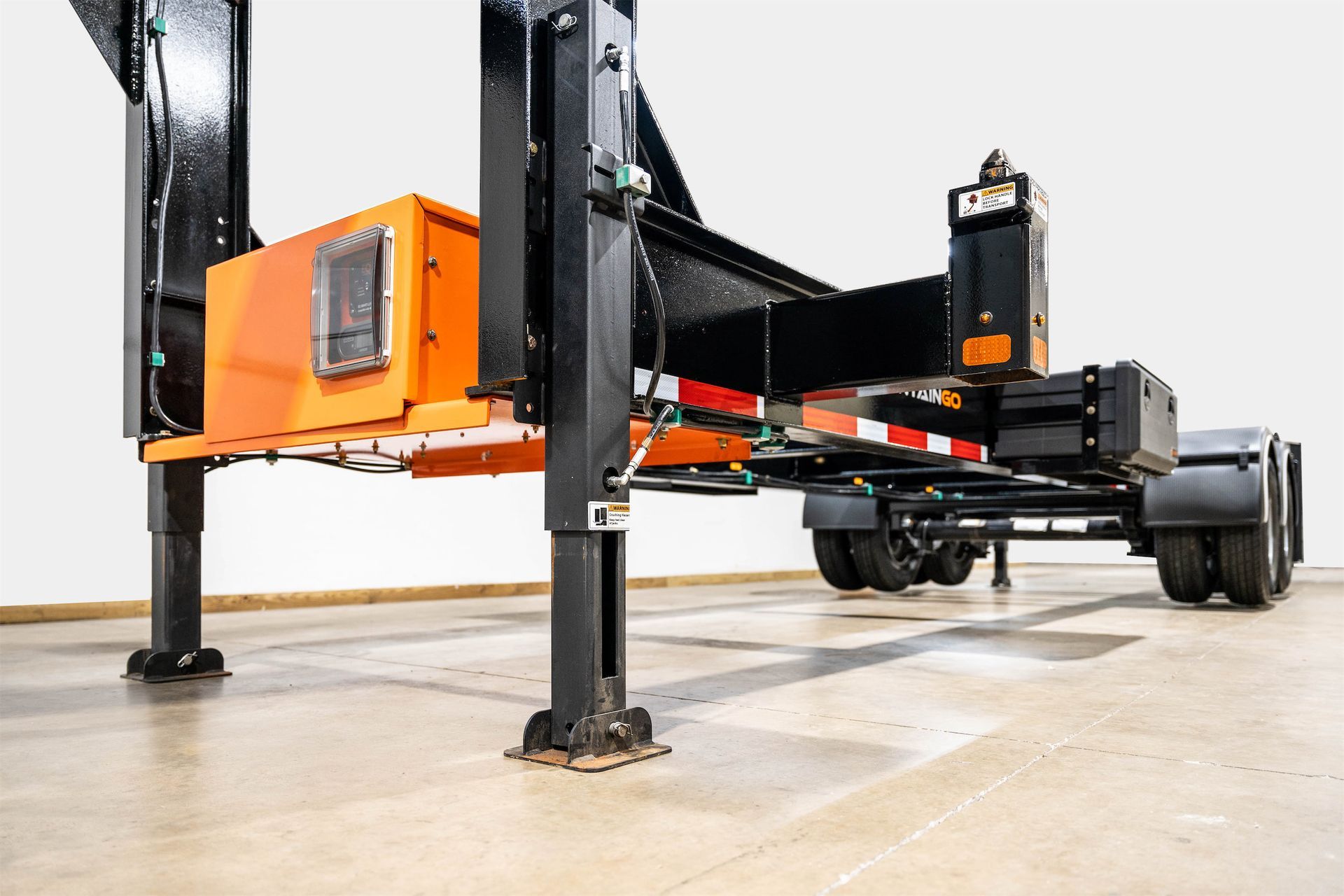 a Container Leveling Chassis Trailer is sitting on a concrete floor in a warehouse .