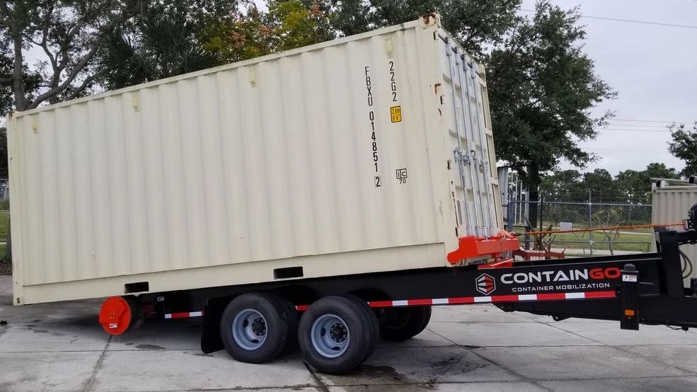 a shipping container is sitting on top of a trailer .