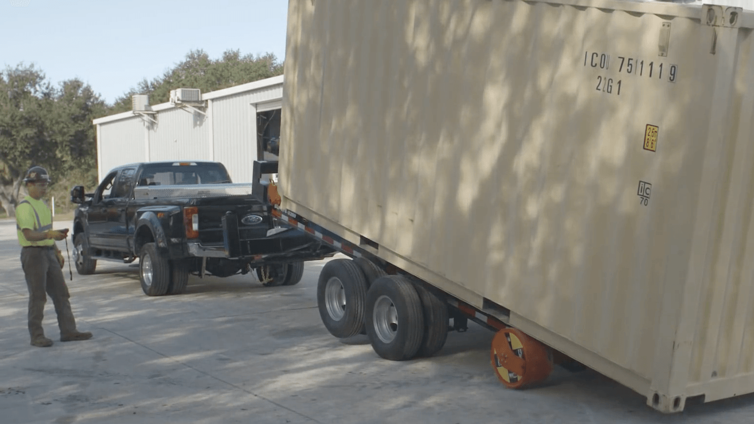 a truck is towing a container on a trailer .