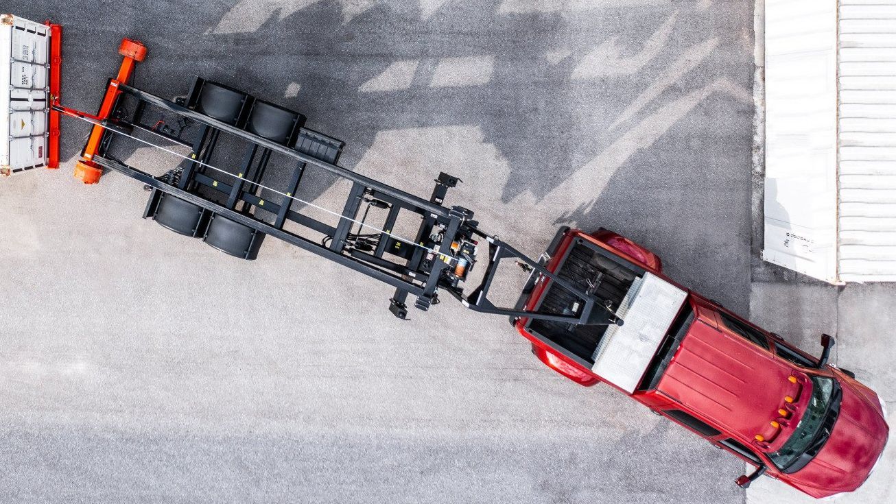 an aerial view of a red truck with a trailer attached to it .