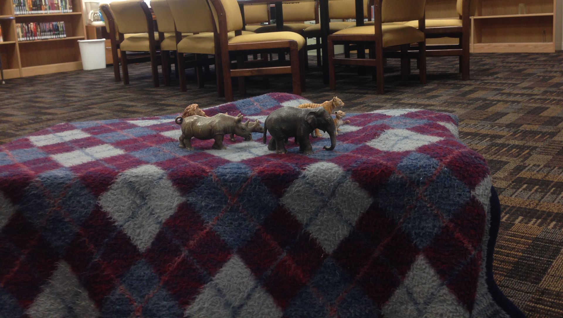 An obstacle-course “cave” made out of a blanket in a church library.