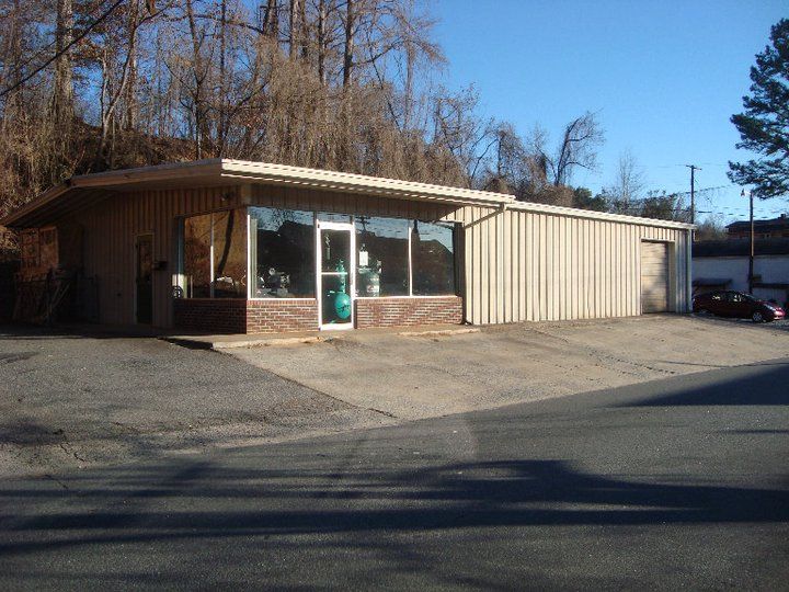 A brick building with a garage and a car parked in front of it