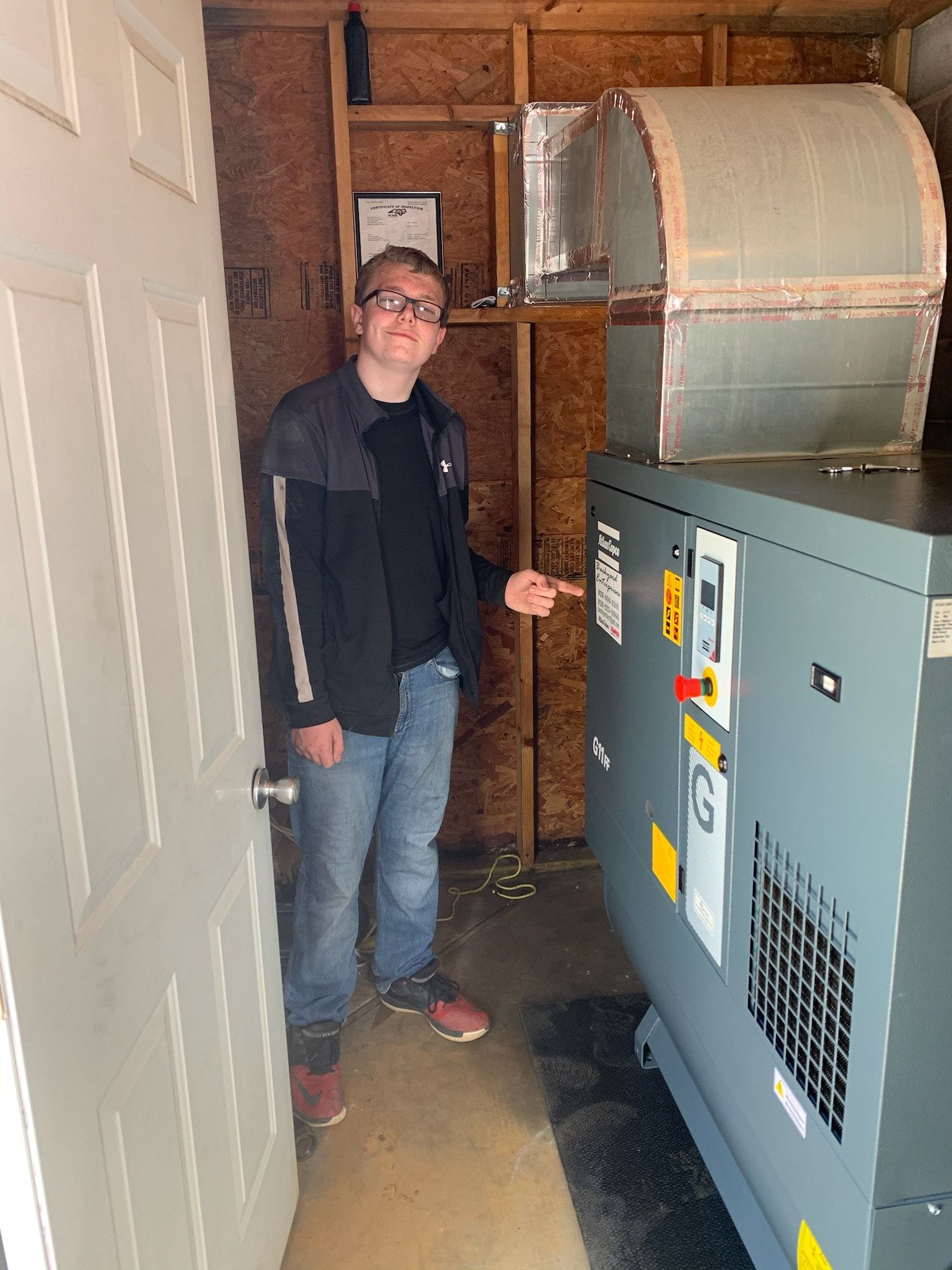 A man is standing in a room next to a machine.