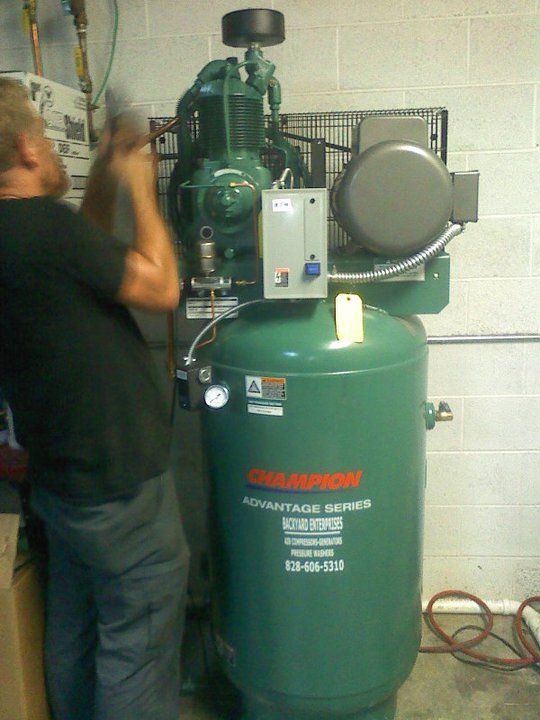 A man is working on a champion air compressor