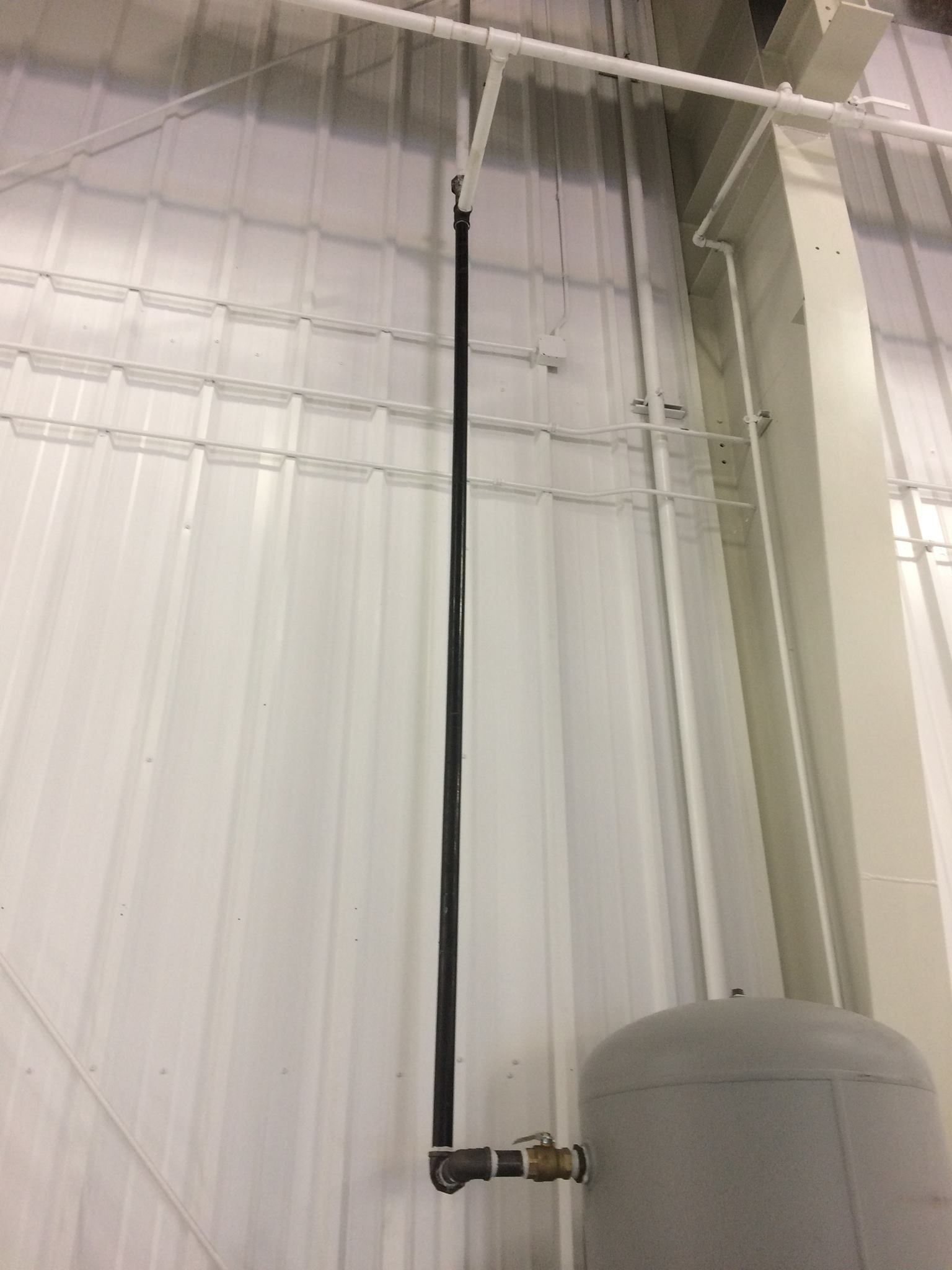 A pipe is hanging from the ceiling of a building.