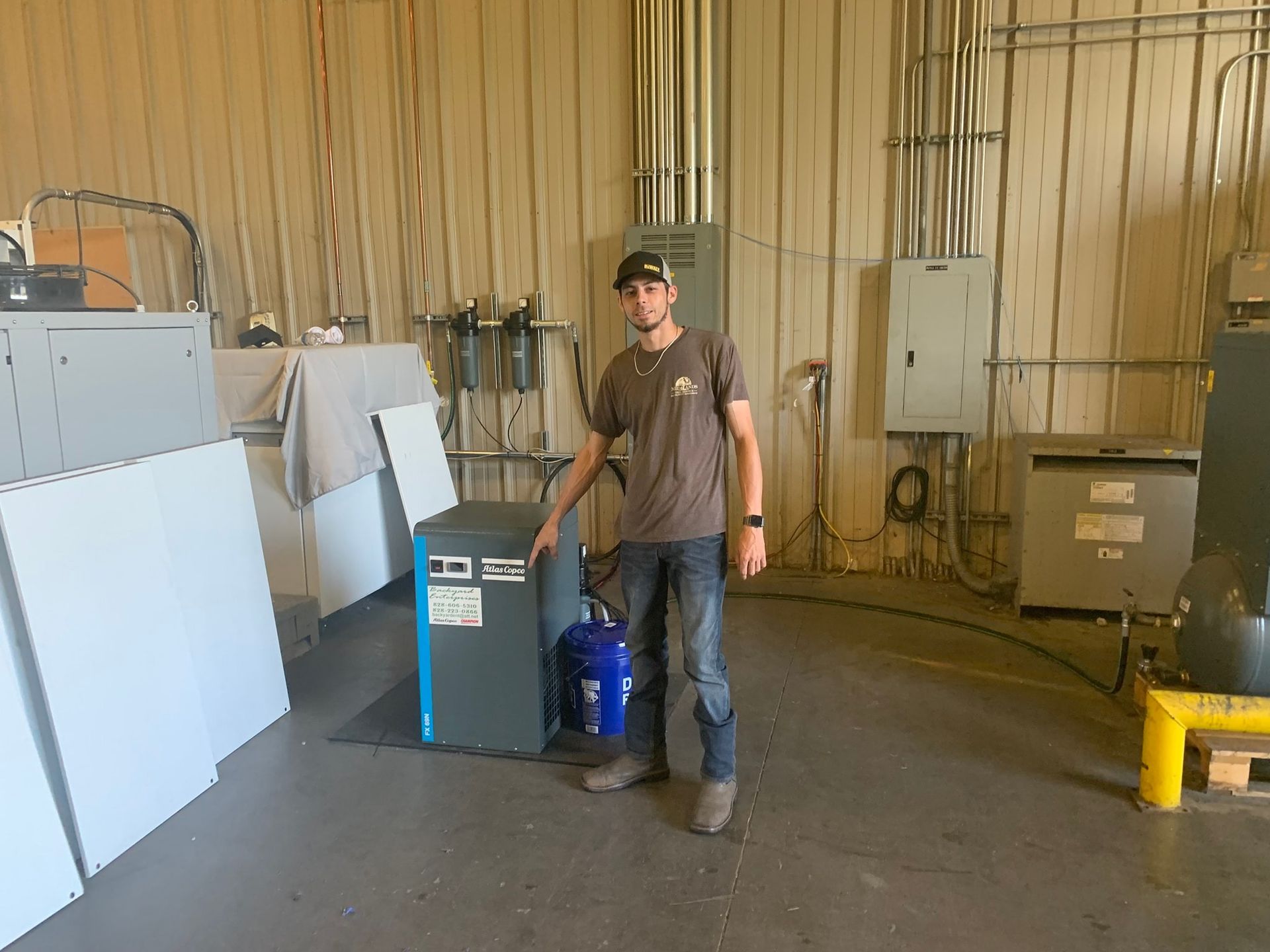A man is standing in a warehouse next to a machine.