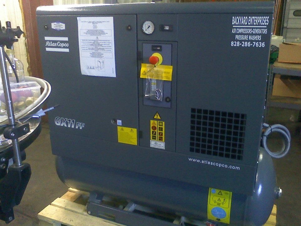 An atlas copco air compressor is sitting on a wooden pallet