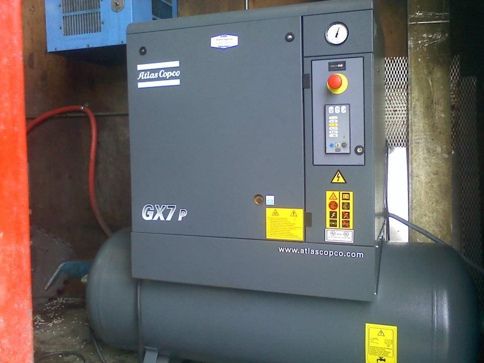 An atlas copco air compressor with a tank attached to it