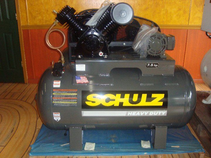 A schulz air compressor is sitting on a blue mat