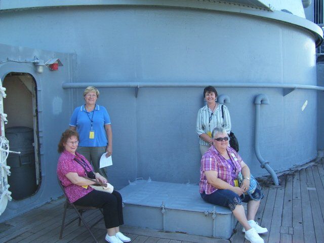 women posing on battleship