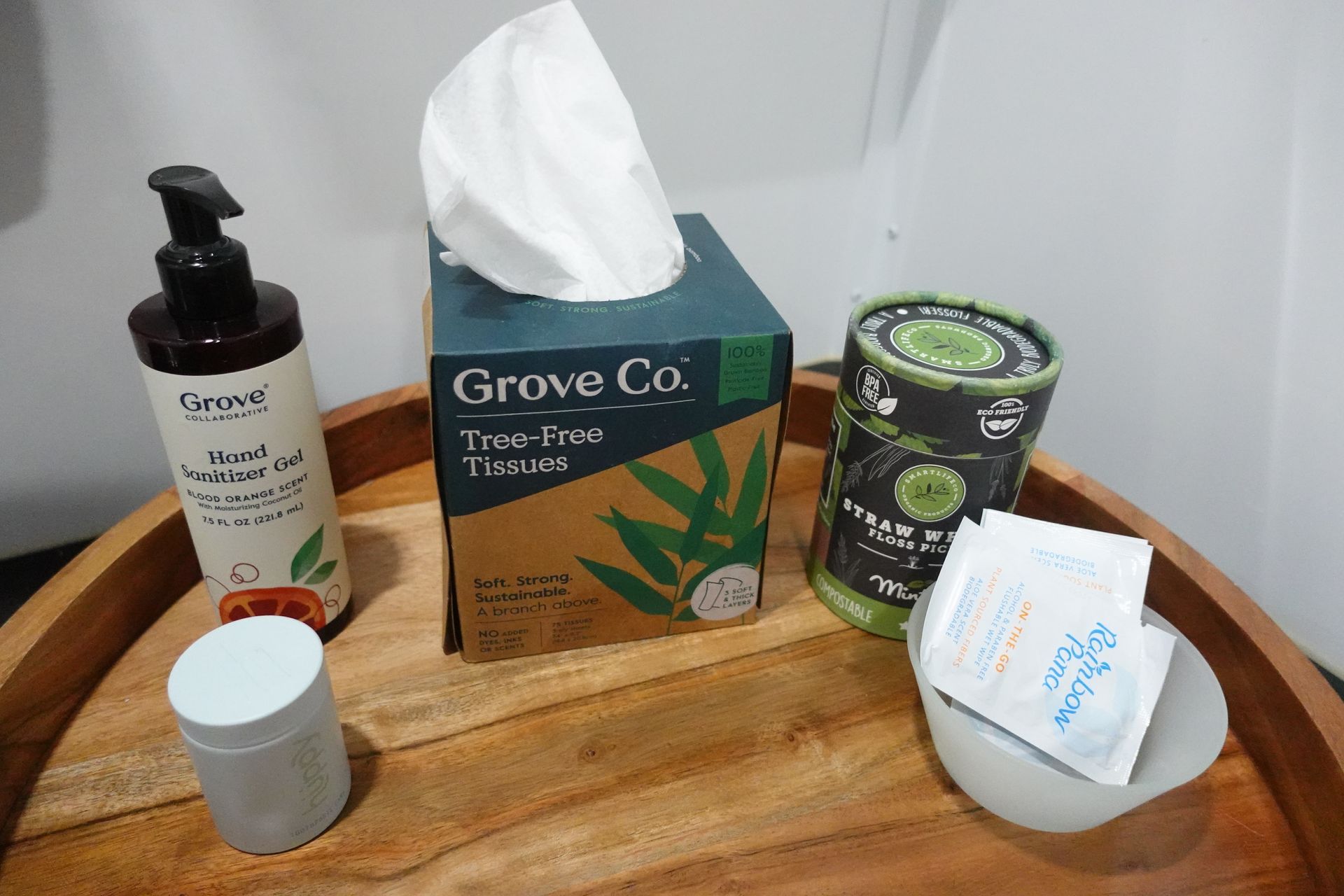 A box of tissues is sitting on a wooden table next to a bottle of lotion.