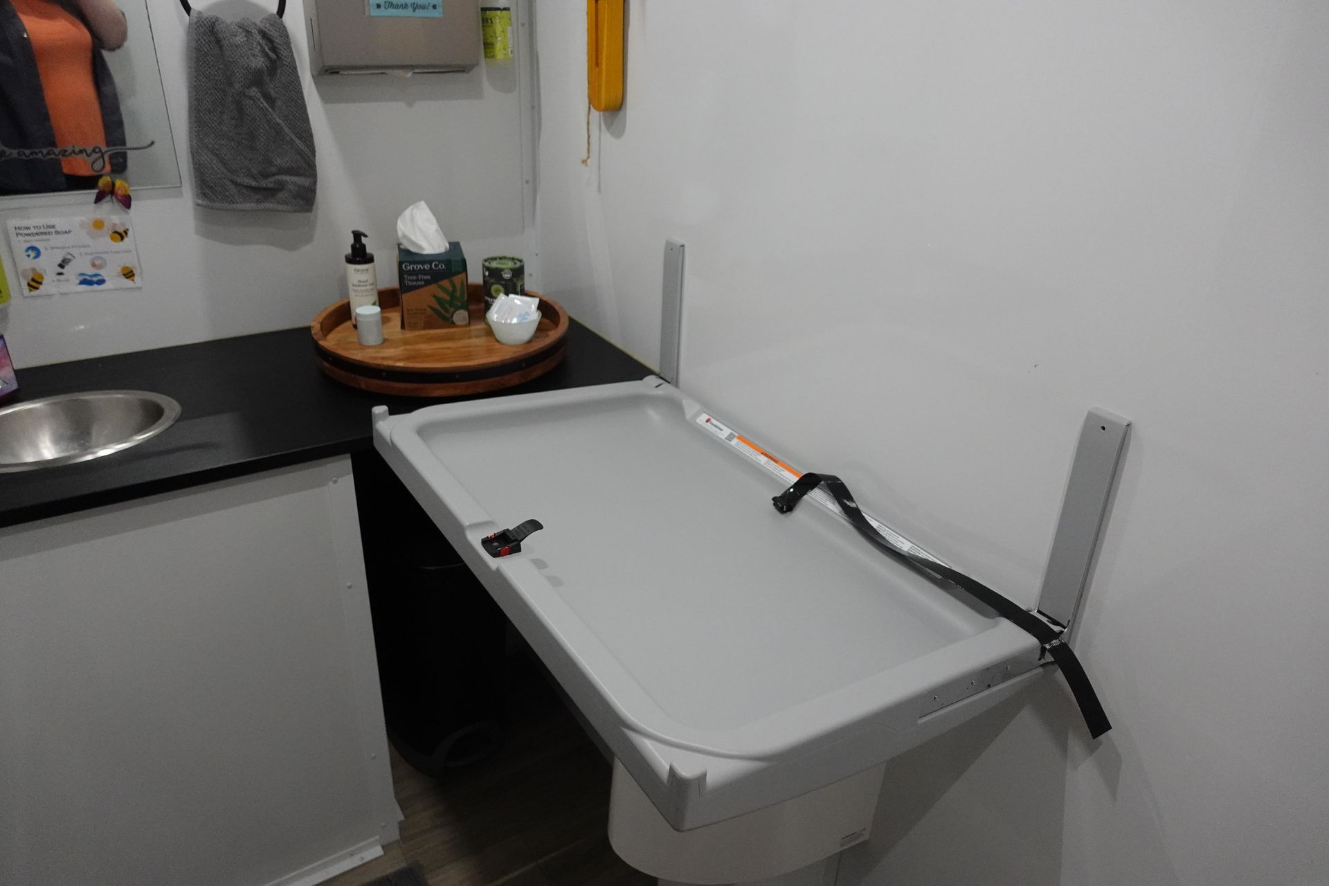 A changing table in a bathroom next to a sink.