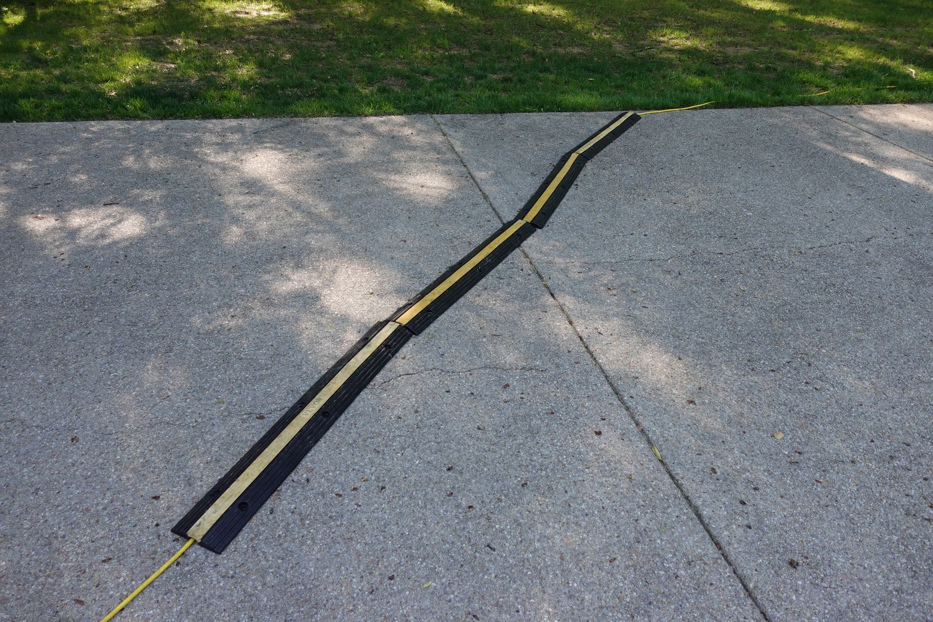 A concrete sidewalk with a yellow line on it.