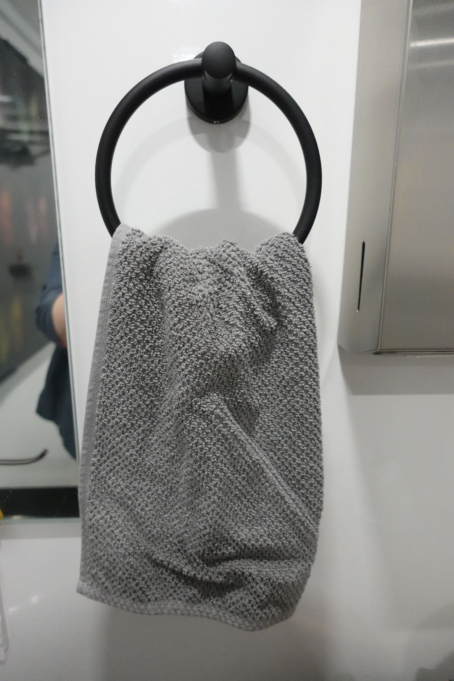 A towel is hanging on a towel ring in a bathroom.