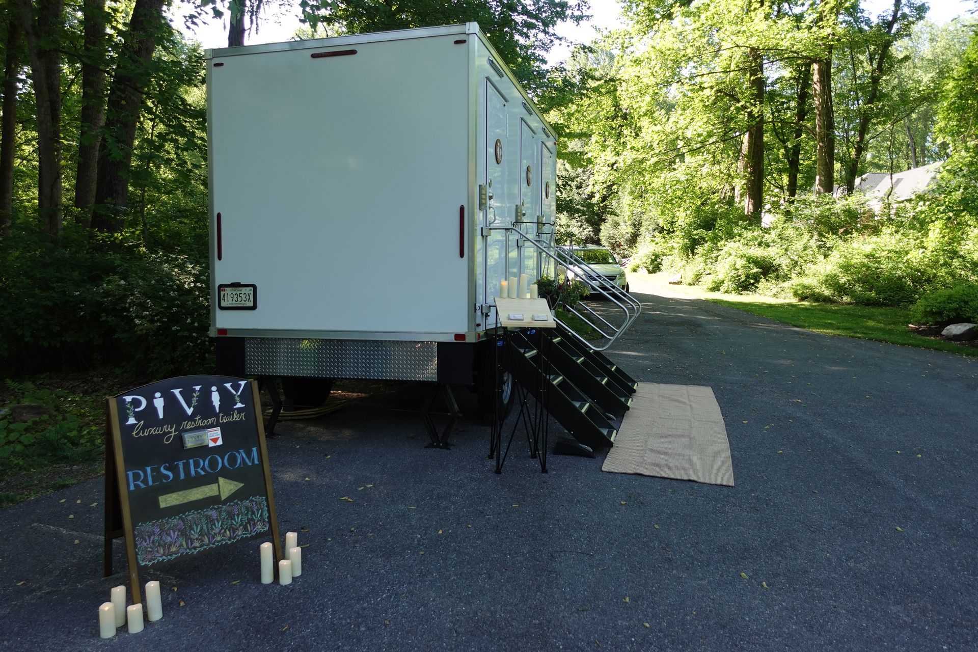 A white trailer is parked next to a sign that says pivy