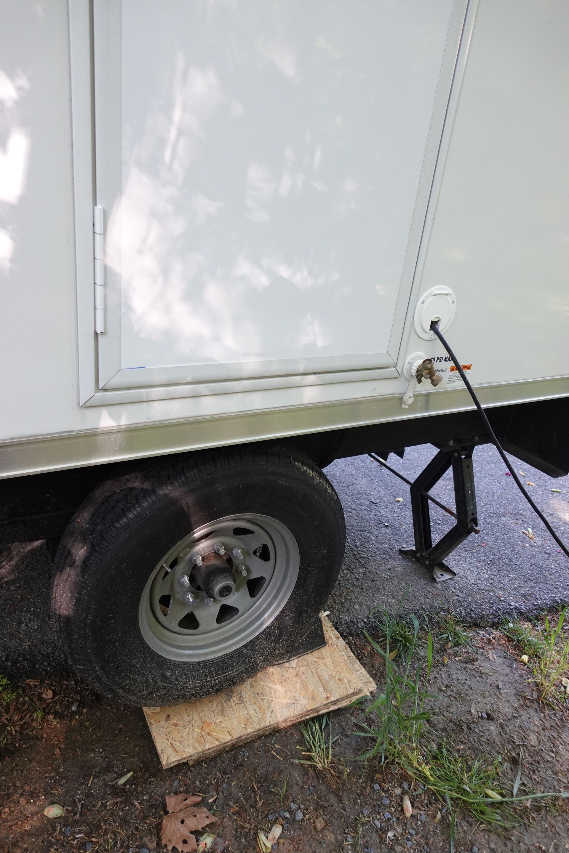 A white trailer is parked on the side of the road.